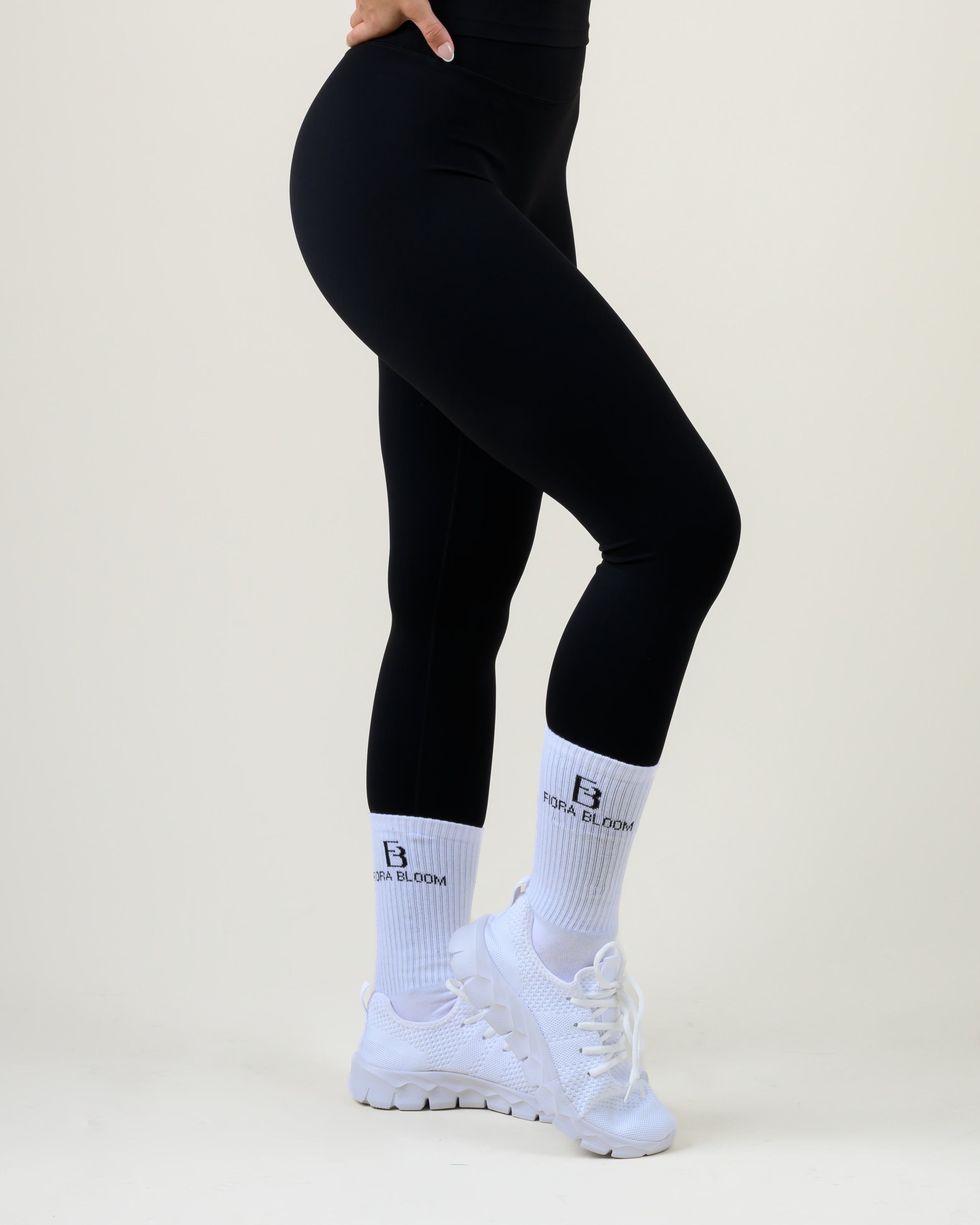 Soft Form High-Waist Leggings in Schwarz von Fiora Bloom – Seitenansicht in Bewegung, zweite Pose, Schrittbewegung, Beinverlauf und Bundsitz sichtbar.