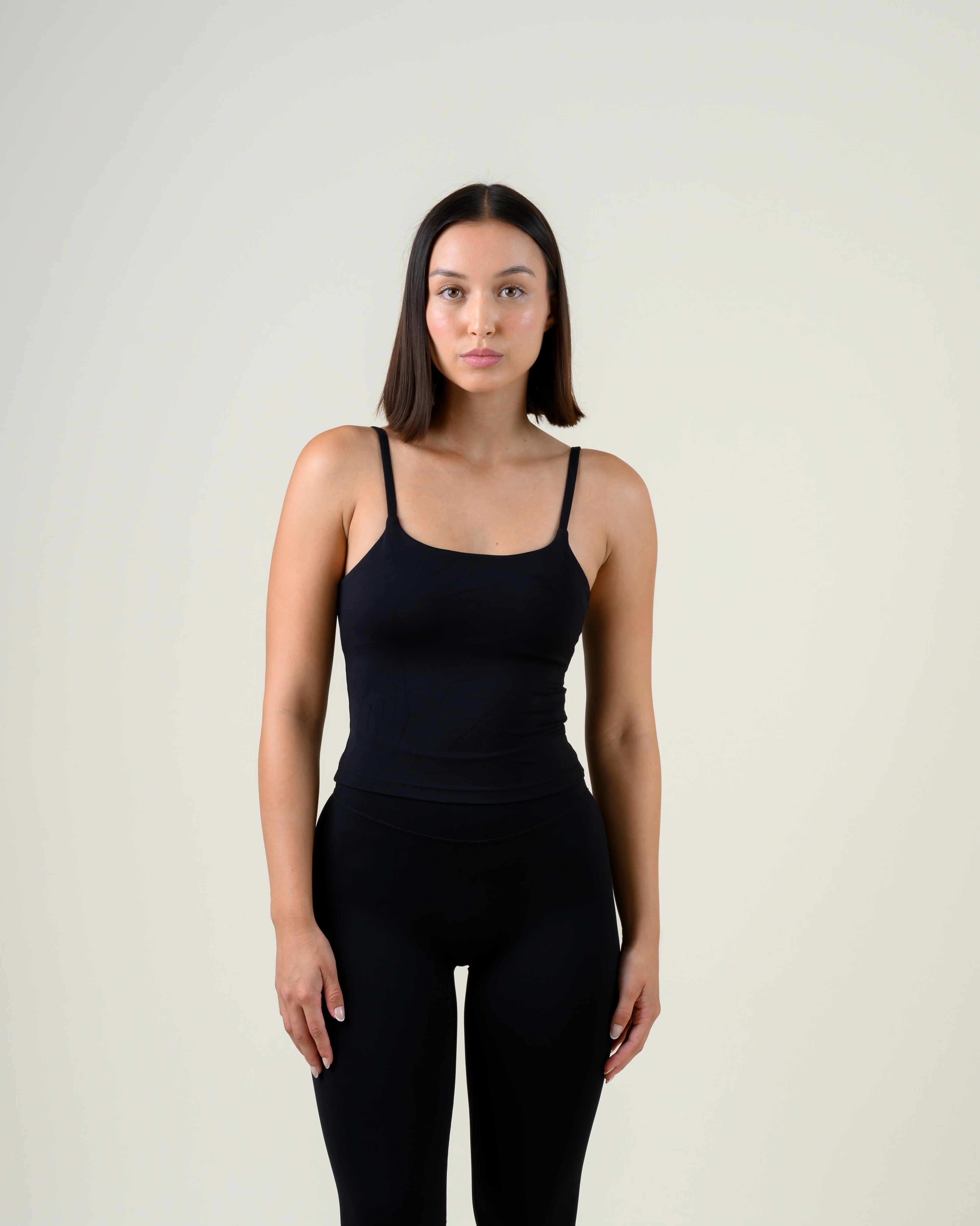 Soft Form Tanktop in Schwarz von Fiora Bloom – Frontansicht, Oberkörper frontal, körpernaher Sitz und Spaghettiträger sichtbar.