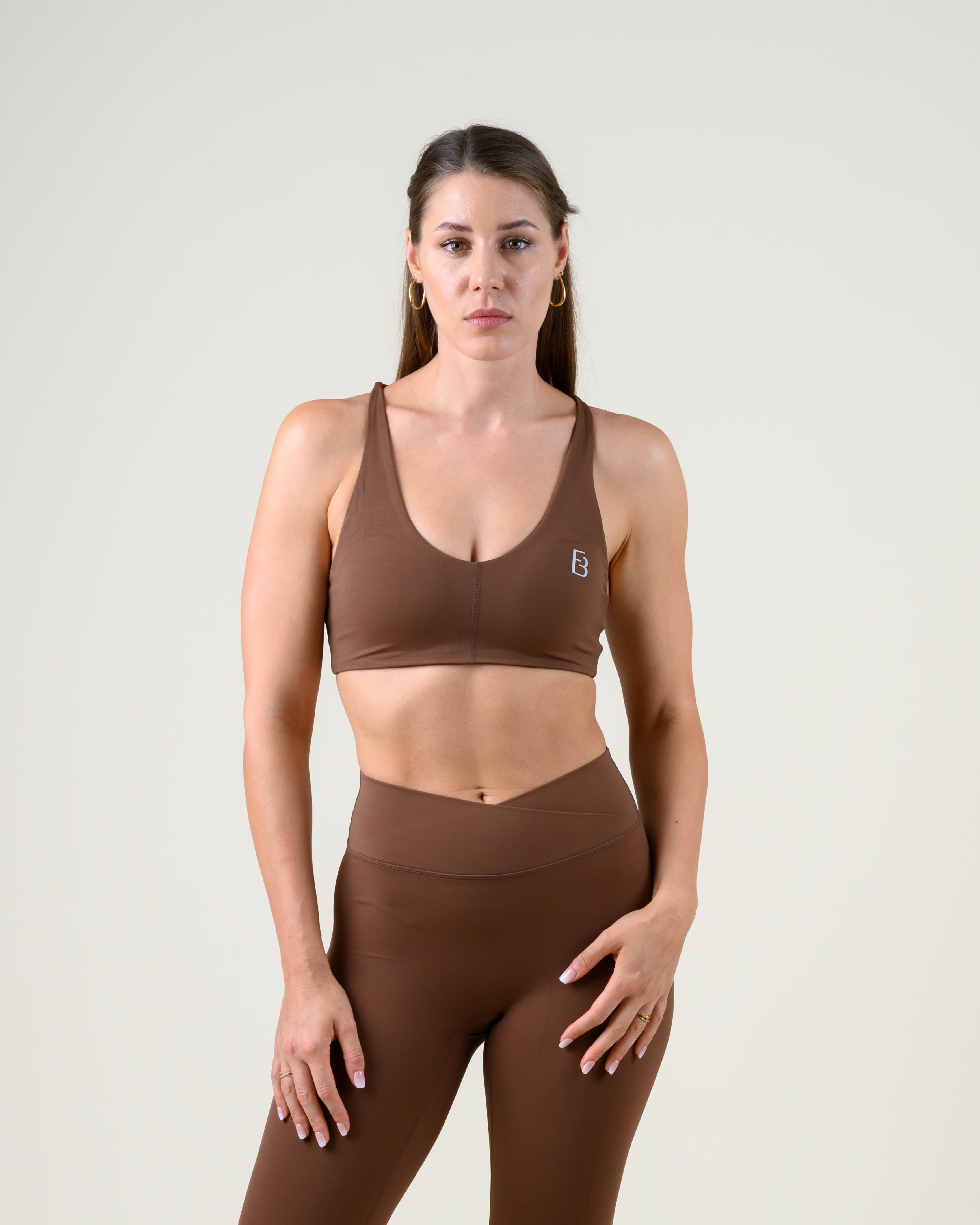 Soft Form Basic Top in Espresso von Fiora Bloom – Frontansicht, zweite Pose, frontal mit gestützten Händen, Stoffspannung sichtbar.