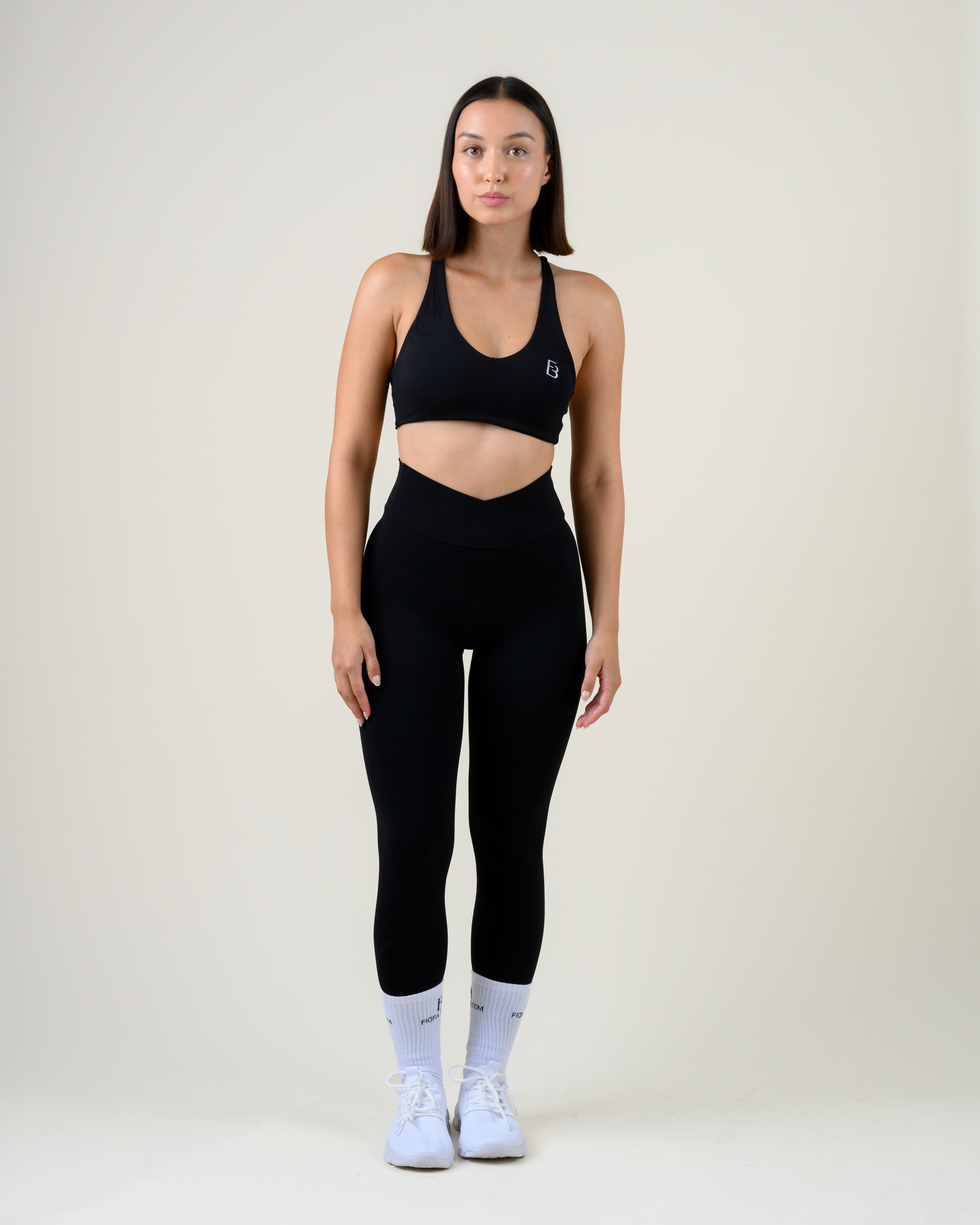 Soft Form Basic Top in Schwarz von Fiora Bloom – Ganzkörper-Look von vorne, kombiniert mit der Soft Form V-Shape Leggings in Schwarz, weisse Socken und Sneaker.