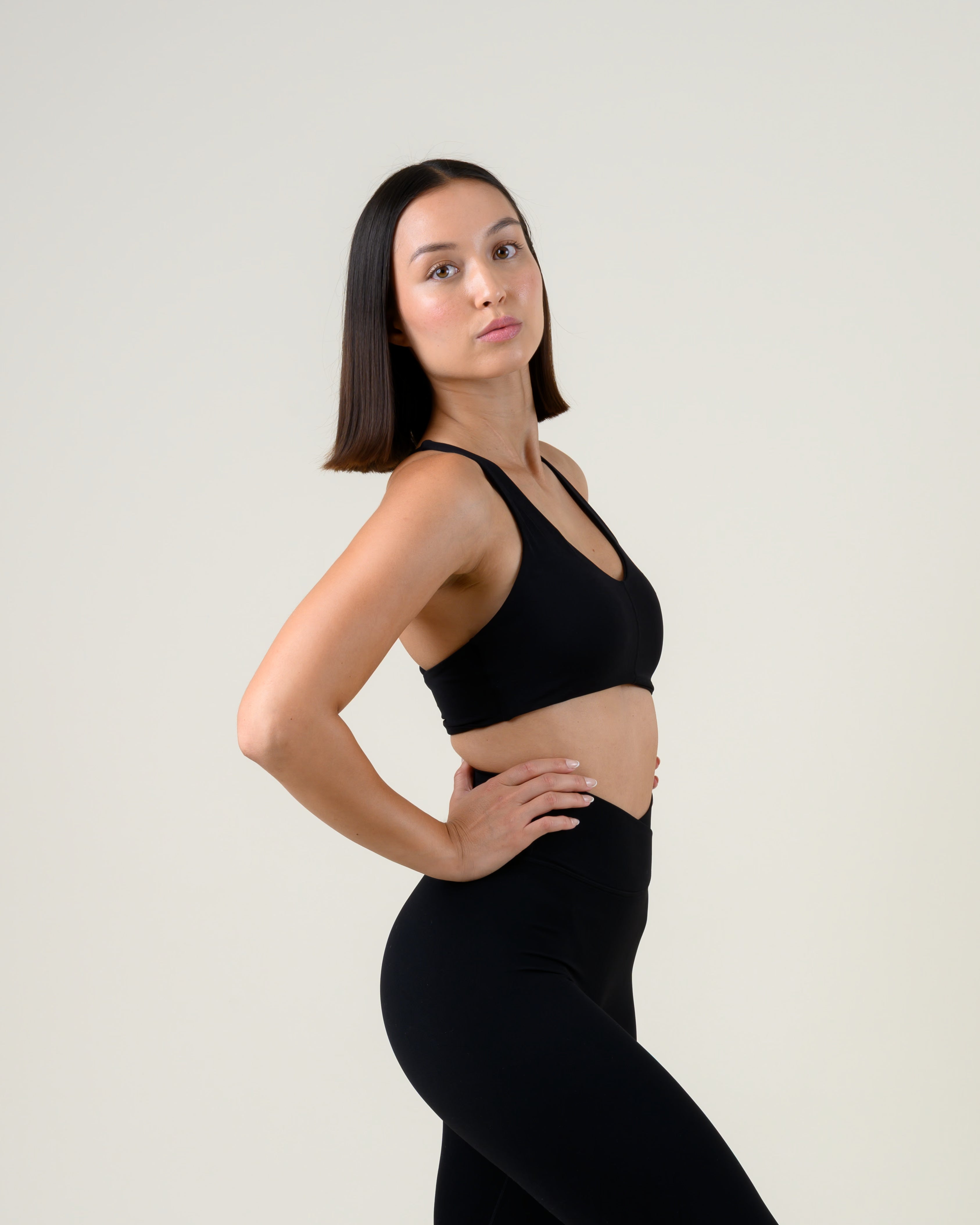 Soft Form Basic Top in Schwarz von Fiora Bloom – Seitenansicht, Seitenprofil, Sitz unter der Brust und Bundhöhe sichtbar.