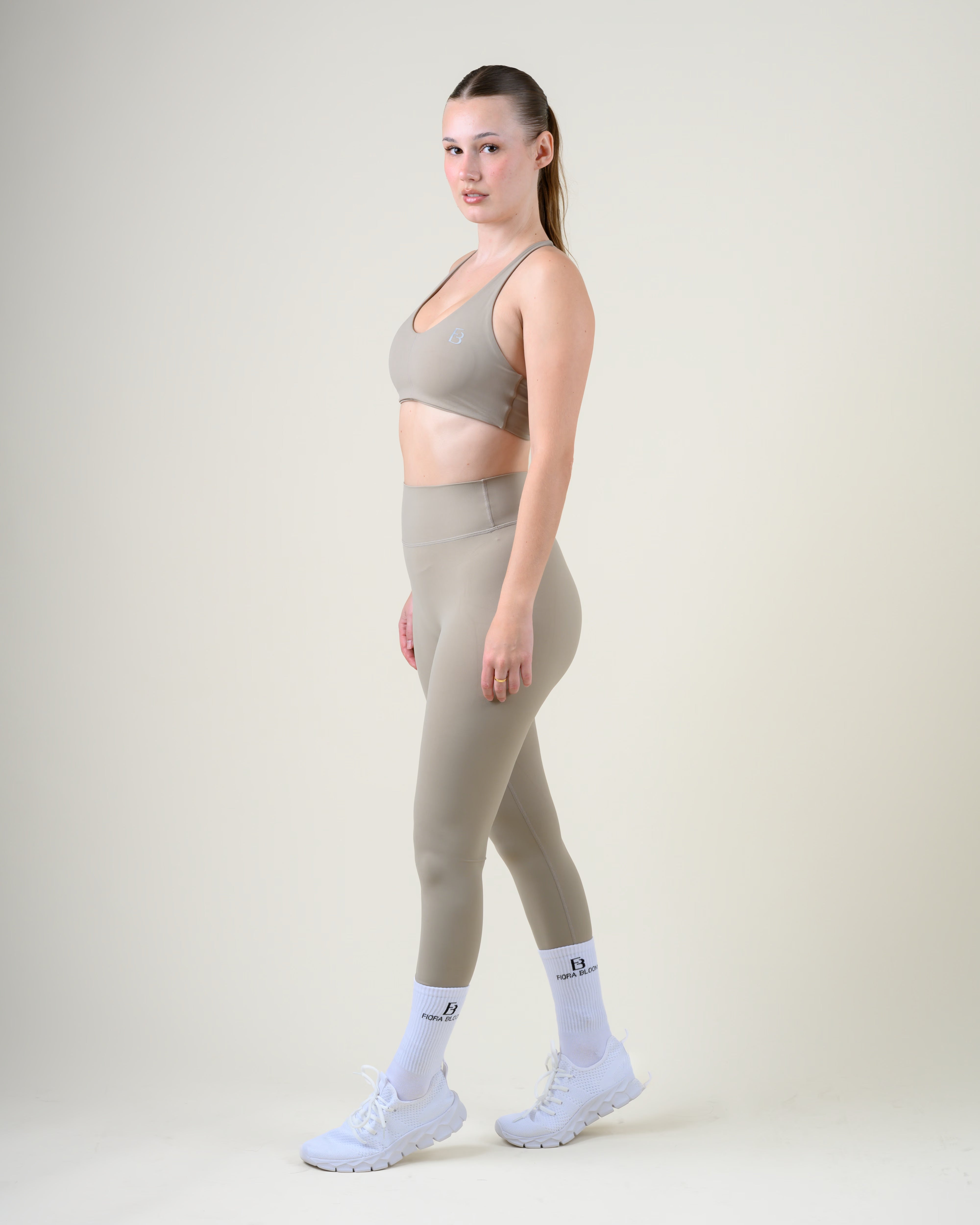 Soft Form High-Waist Leggings in Taupe von Fiora Bloom – Ganzkörper-Look von der Seite, kombiniert mit dem Soft Form Basic Top in Taupe, weisse Socken und Sneaker.