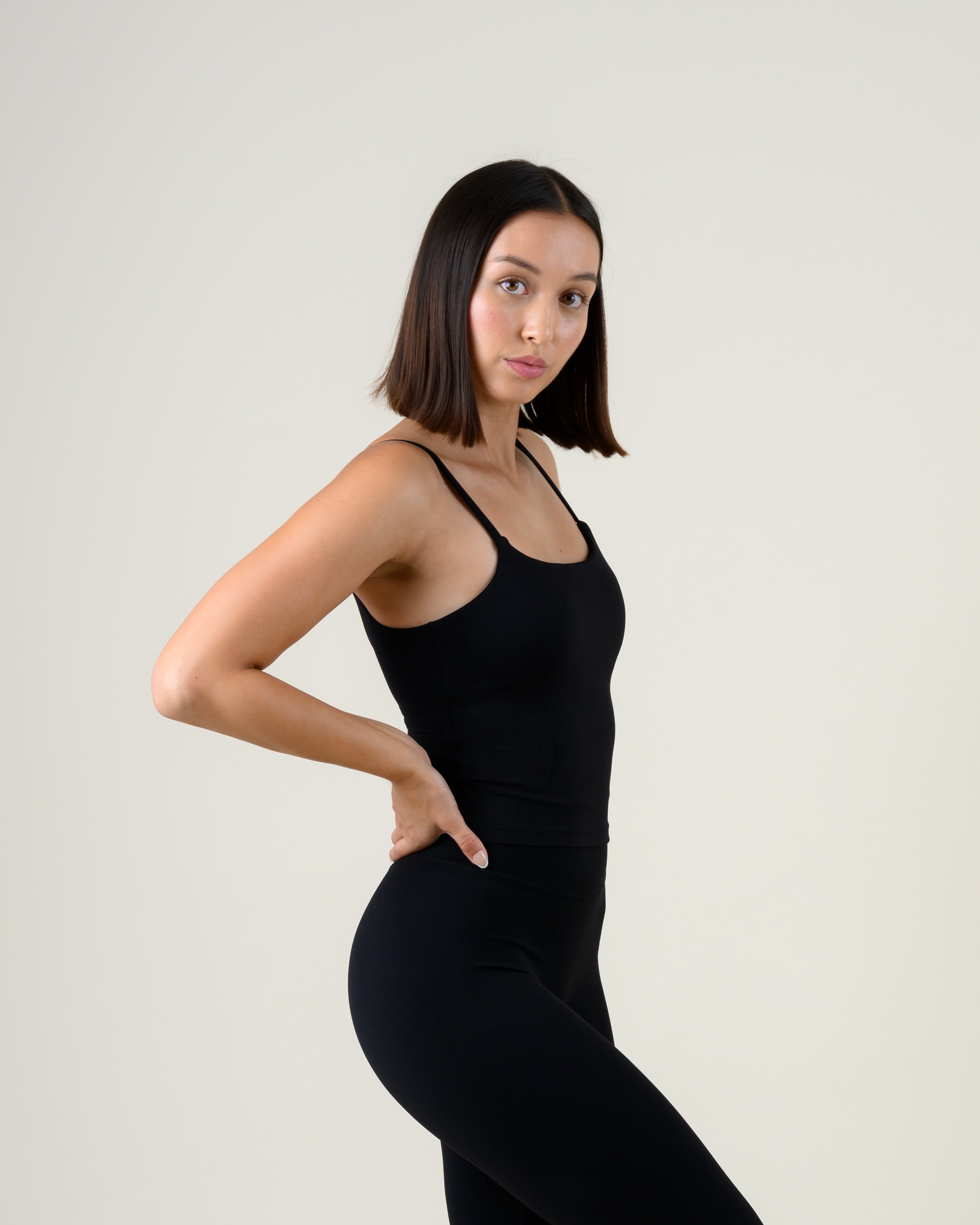 Soft Form Tanktop in Schwarz von Fiora Bloom – Seitenansicht, seitliche Haltung, Sitz an Taille und Hüfte sichtbar.