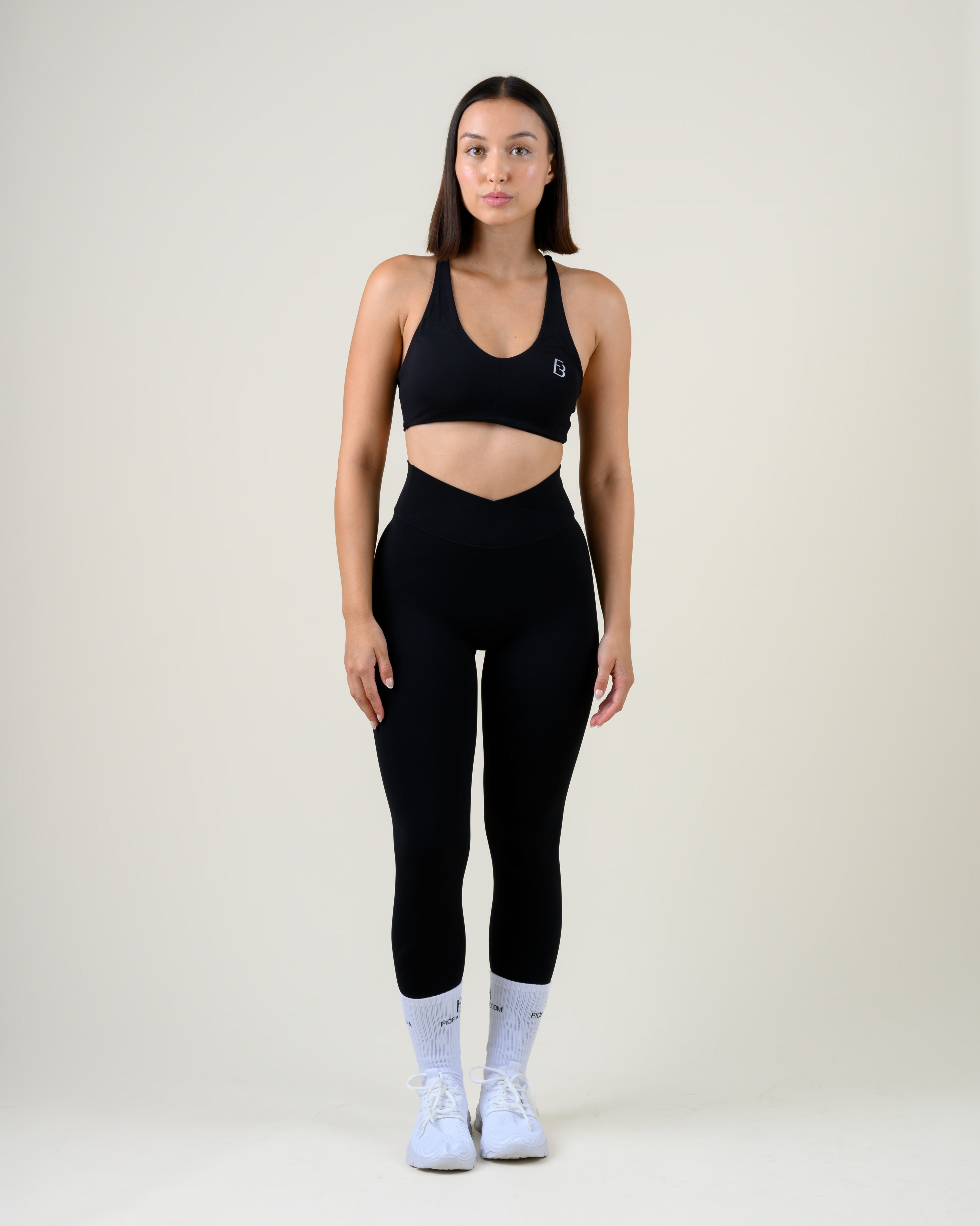 Soft Form V-Shape Leggings in Schwarz von Fiora Bloom – Ganzkörper-Look von vorne, kombiniert mit dem Soft Form Basic Top in Schwarz, weisse Socken und Sneaker.