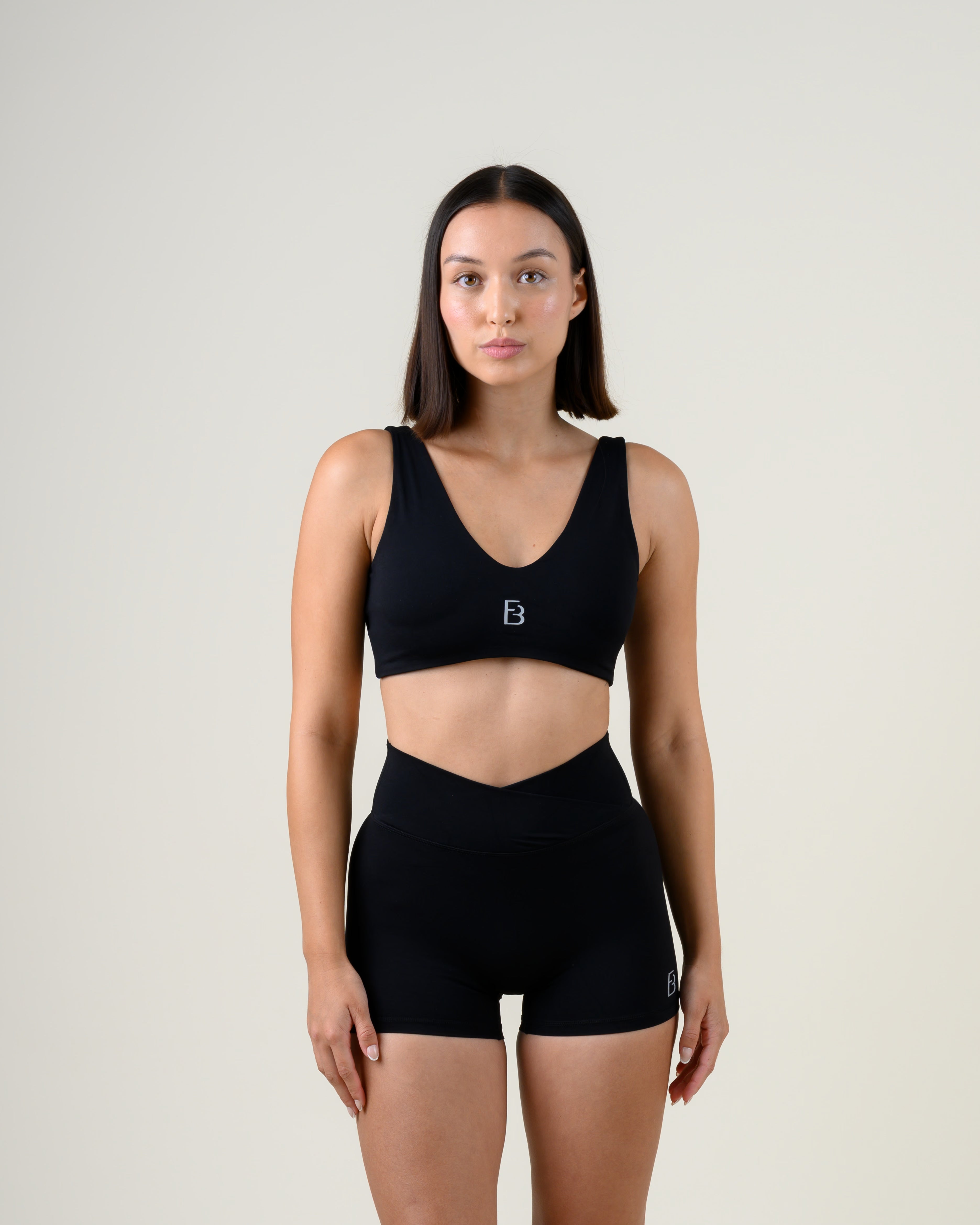 Soft Form V-Top in Schwarz von Fiora Bloom – Frontansicht, Oberkörper frontal, V-Ausschnitt und breite Träger sichtbar.